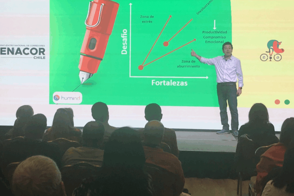 Fotografía de Rodrigo Saa en una conferencia en Chile, señalando una gráfica sobre fortalezas y desafíos frente a una audiencia atenta.