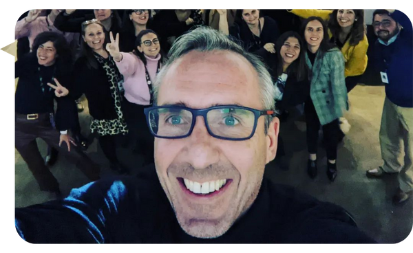 Patrick Mork tomando una selfie grupal con participantes sonrientes en uno de sus talleres o conferencias.