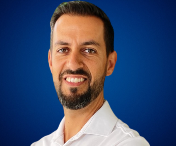 Fotografía de Miguel Ángel Ronda, profesor y divulgador en Inteligencia Artificial y Big Data, sonriendo frente a un fondo azul.