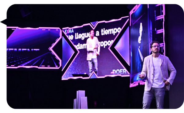 Borja Castelar en el escenario durante una conferencia, con pantallas grandes proyectando su imagen y mensajes clave.