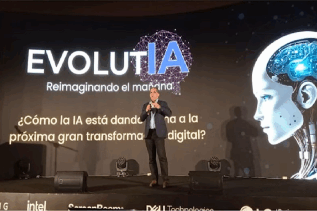 Fotografía de Jaime Montenegro en el escenario de EVOLUTIA, evento sobre inteligencia artificial, con fondo visual de cerebro digital y androide futurista, presentando sobre transformación digital.