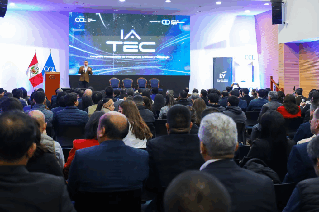 Fotografía de Jaime Montenegro exponiendo en el Congreso Internacional de Inteligencia Artificial y Tecnología (IA TEC), ante una audiencia llena, con banderas de Perú y CCL al fondo y una pantalla con gráficos digitales.