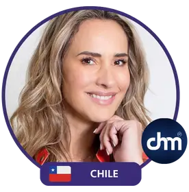 Angélica Castro, conferencista y coach de vida de Chile, sonriendo y destacada con la bandera chilena y el logo de CHM