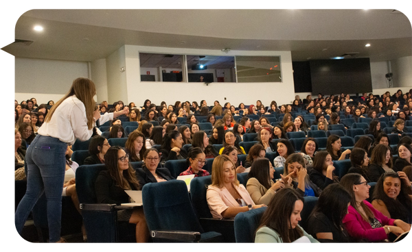 Bárbara Contreras interactuando con un auditorio lleno de mujeres