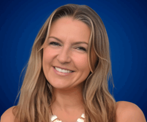 Retrato profesional de Luz Amparo Álvarez sonriendo, con fondo azul.