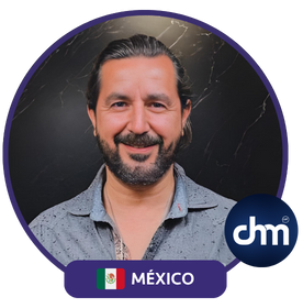 Fotografía de Daniel Villarreal Alanís, conferencista de México, sonriendo con una camisa gris frente a un fondo oscuro, destacando su presencia profesional.