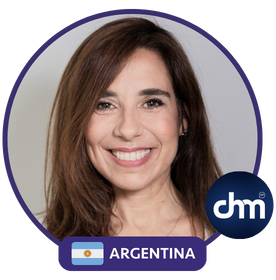 Retrato de Natalia De Vita, mujer de cabello castaño largo, sonriendo, con un diseño circular, la bandera de Argentina y el logo de Charlas Motivacionales.