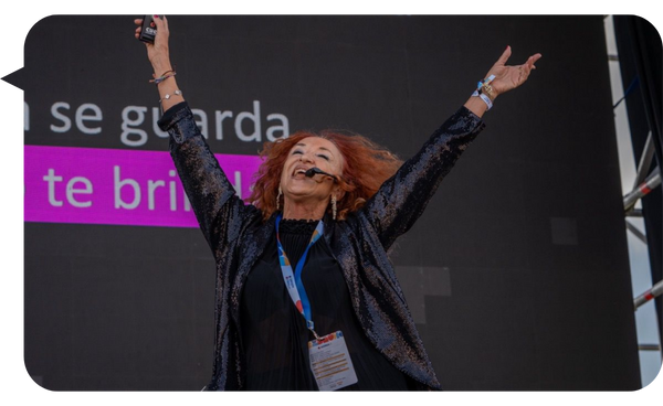 Silvia Escribano enérgica en el escenario, con los brazos levantados y sonriendo.