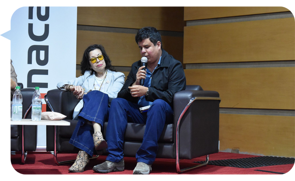 José Cuadra hablando en un panel de discusión, sentado junto a una compañera de panel.