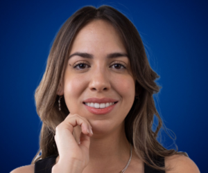 Retrato de Alejandra Tejeda sonriendo, con fondo azul.