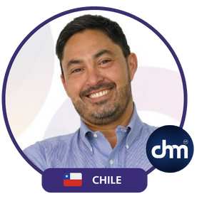 Claudio López Moreno, conferencista internacional, sonriendo y representando a Chile, especializado en diseño de servicios y liderazgo humano, con un fondo claro y el logo de CHM