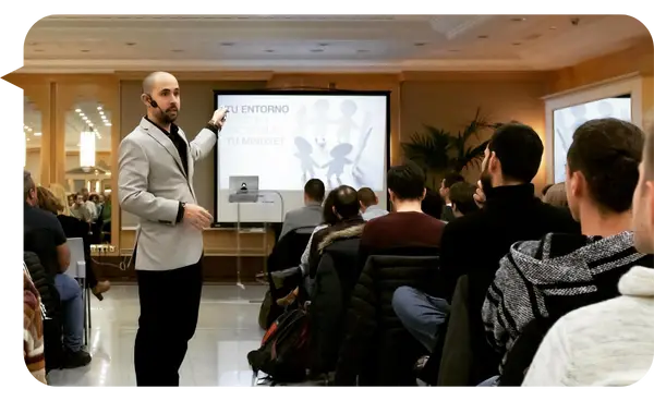 Alejandro Kei explicando cómo el entorno afecta el mindset durante una conferencia ante una audiencia atenta.