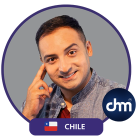 Joaquín Pincheira, conferencista chileno especializado en felicidad y motivación personal, posando con una sonrisa y señalando su cabeza, representando a Chile.