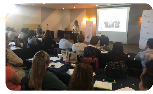 Mariana Hernández impartiendo un taller en una sala de conferencias llena de asistentes.