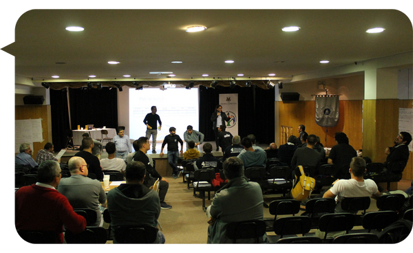 Julián Mendiola liderando una dinámica interactiva en un auditorio lleno de participantes atentos.