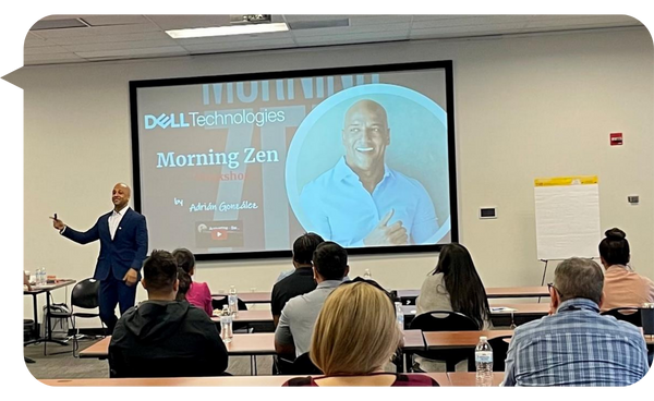 Adrián González dirigiendo un taller llamado "Morning Zen" para Dell Technologies ante un grupo de participantes en un salón de conferencias.