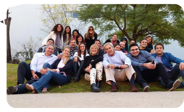 Cristian Martín Maqui y un grupo de personas sonrientes posando juntos al aire libre.