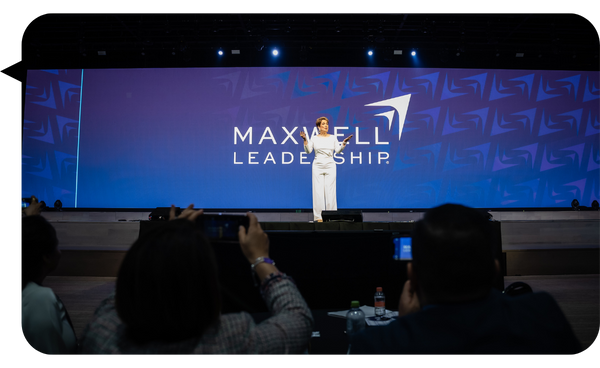 Janine Sikaffy en el escenario del Maxwell Leadership, captada mientras ofrece su conferencia a una audiencia.