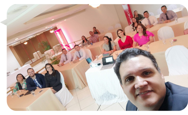 Leo Rodríguez toma una selfie durante un taller interactivo con un grupo de profesionales en un ambiente relajado y participativo.