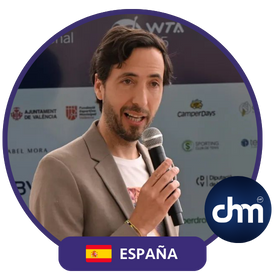 David Blay Tapia hablando en un evento, con micrófono en mano, fondo promocional y etiqueta de España.