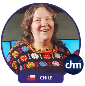 Sylvia Langford sonriendo con una blusa colorida, junto al logotipo de Chile y el distintivo "chm".