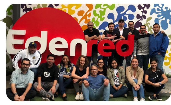 Adolfo Alvarez León junto a su equipo frente al logotipo de Edenred, en un entorno de trabajo colaborativo.