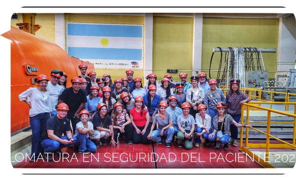 Grupo de personas con cascos de seguridad naranjas en una visita industrial, con una bandera de Argentina en el fondo.