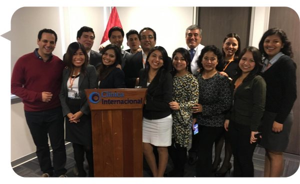 Grupo de profesionales en la Clínica Internacional posando junto a un podio con el logotipo de la clínica.