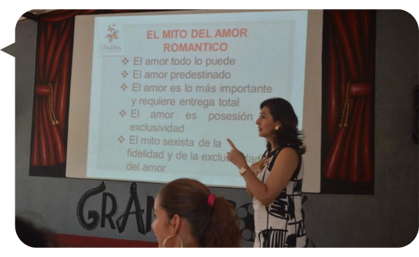 Beatriz Ramírez, conferencista, hablando sobre el mito del amor romántico en una presentación.