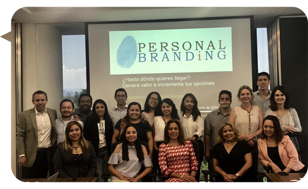 Franco Borges junto a un grupo de asistentes durante un taller sobre Marca Personal en un entorno corporativo.