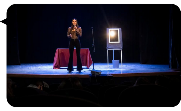 Gabriela Téllez en el escenario durante una conferencia, transmitiendo mensajes inspiradores sobre inteligencia emocional frente a un público atento.