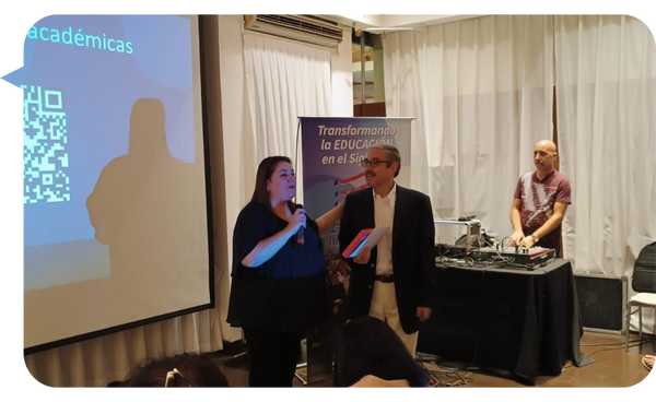 Juan Manuel Manes participando en una conferencia sobre educación junto a una colega.