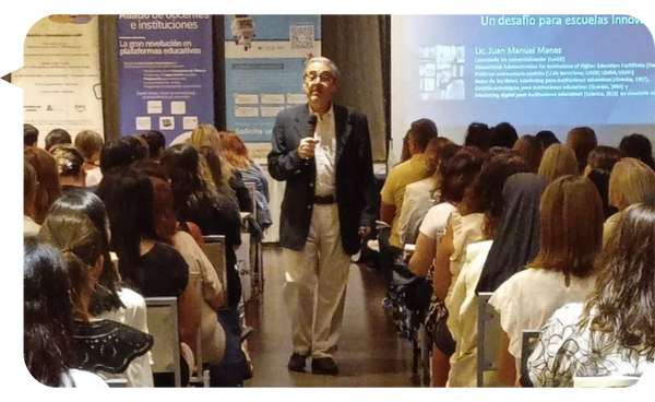 Juan Manuel Manes impartiendo una conferencia sobre innovación en escuelas, frente a un auditorio lleno.