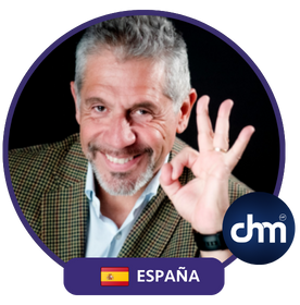 Pancho Campo haciendo un gesto de aprobación con la mano, vestido con una chaqueta a cuadros y camisa blanca, enmarcado en un diseño circular con la bandera de España y el logo "dm".