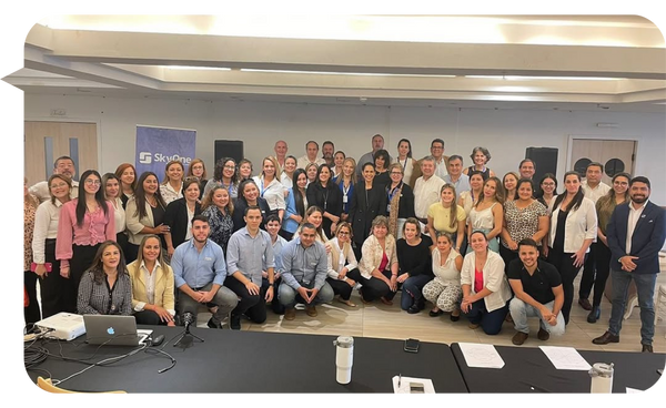 "Grupo de profesionales reunidos en un evento organizado por SkyOne Real Estate, con Daniel Ortiz al frente junto a los participantes."