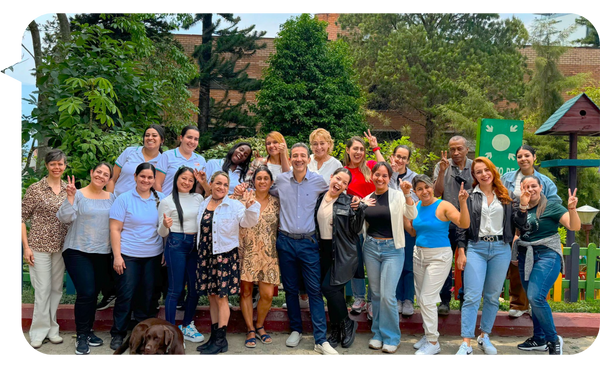 Grupo de personas al aire libre sonriendo después de una sesión de formación liderada por Juan David Londoño.