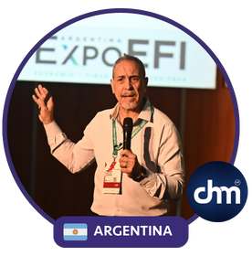 Marcelo Carbone durante una conferencia en ExpoEFI, hablando al público con micrófono en mano y fondo con cartel del evento.