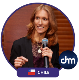 Kim Brierley, conferencista internacional de Chile, sosteniendo un micrófono mientras dirige una presentación con entusiasmo y profesionalismo.