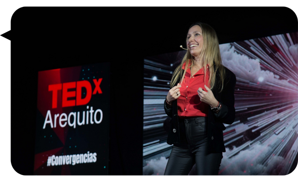 Verónica Dobronich hablando en el escenario de TEDx Arequito, inspirando al público con su charla sobre inteligencia emocional y liderazgo.