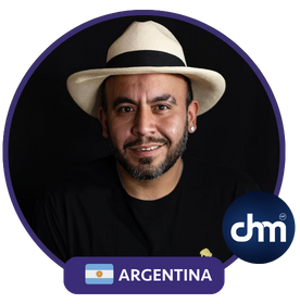 Retrato de Gaspar Contreras, hombre con barba corta y sombrero blanco, vistiendo una camiseta negra, con una sonrisa amigable y fondo oscuro. La imagen incluye un marco circular con la bandera de Argentina y el logo de "dhm".