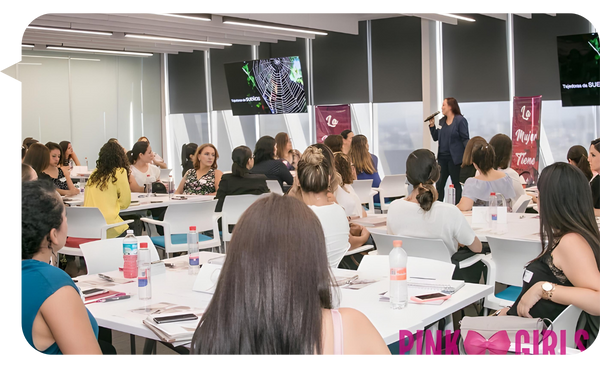 Conferencia de Ariadna Tamayo en un evento de empoderamiento femenino, con una audiencia atenta en un espacio moderno y bien iluminado.