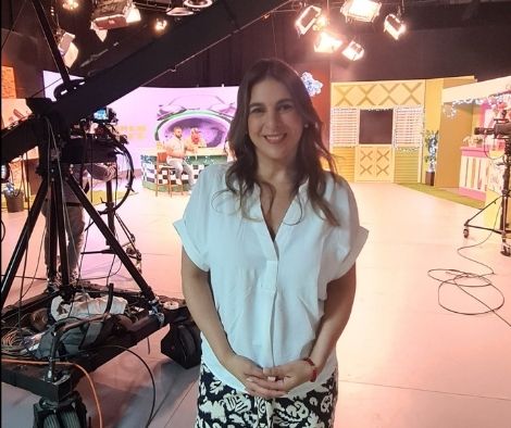 Vivianne Verschae en el set de grabación de un programa de televisión, sonriente frente a cámaras y luces de estudio.