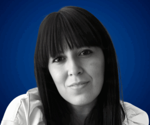 Noelia Centeno, psicóloga clínica y conferencista en desarrollo personal, en retrato profesional con fondo azul.