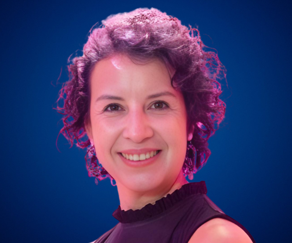 Susana Cáceres González, speaker internacional y experta en comunicación interna, en retrato profesional con fondo azul.