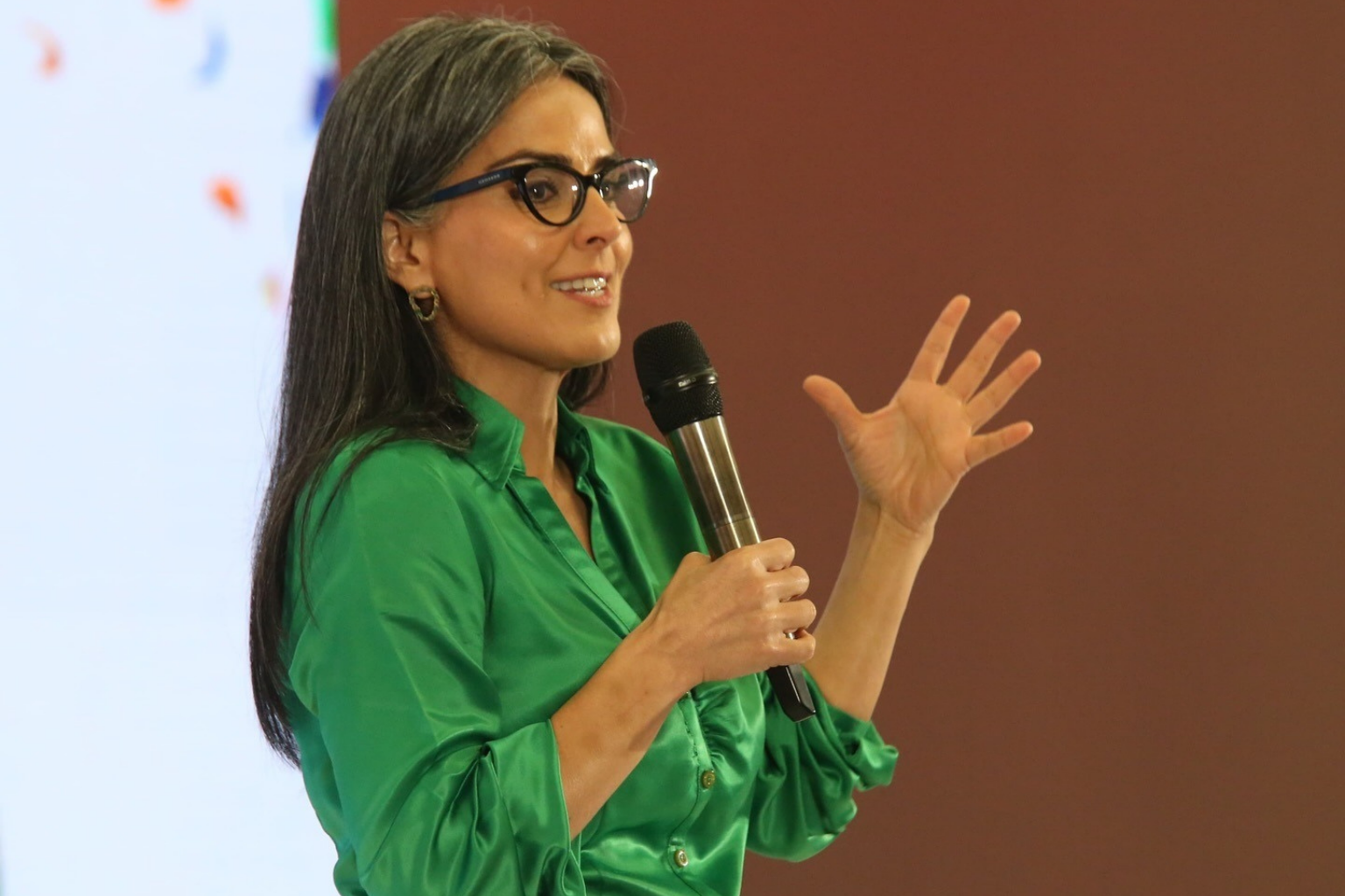 Claudia Palacios impartiendo conferencia sobre liderazgo femenino y comunicación efectiva.
