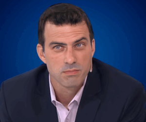 Darío Rubinsztein en primer plano, conferencista argentino experto en economía, liderazgo y empresas familiares, sobre fondo azul.