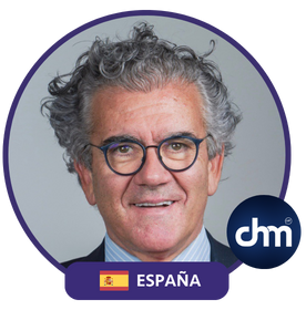 Juan Carlos Alcaide, experto en experiencia de cliente, marketing y Silver Economy, con gafas y traje oscuro, fondo gris claro.