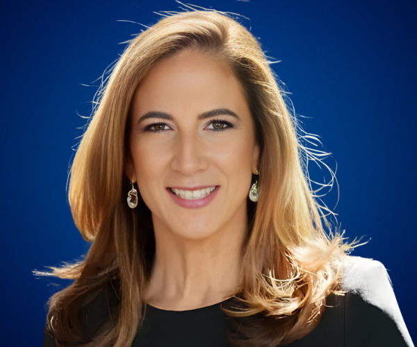 Retrato profesional de Patricia Arboleda, coach ejecutiva, con fondo azul y expresión amable.