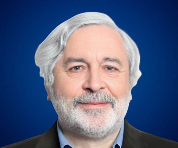 Retrato profesional de Roberto Alejandro Llauró, conferencista senior con cabello canoso, barba blanca y fondo azul.