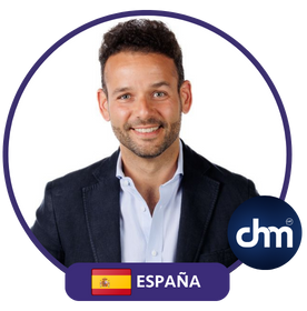 Sebastián Lora con chaqueta oscura y camisa blanca, imagen de perfil profesional con la bandera de España y logo de Charlas Motivacionales Latinoamérica.